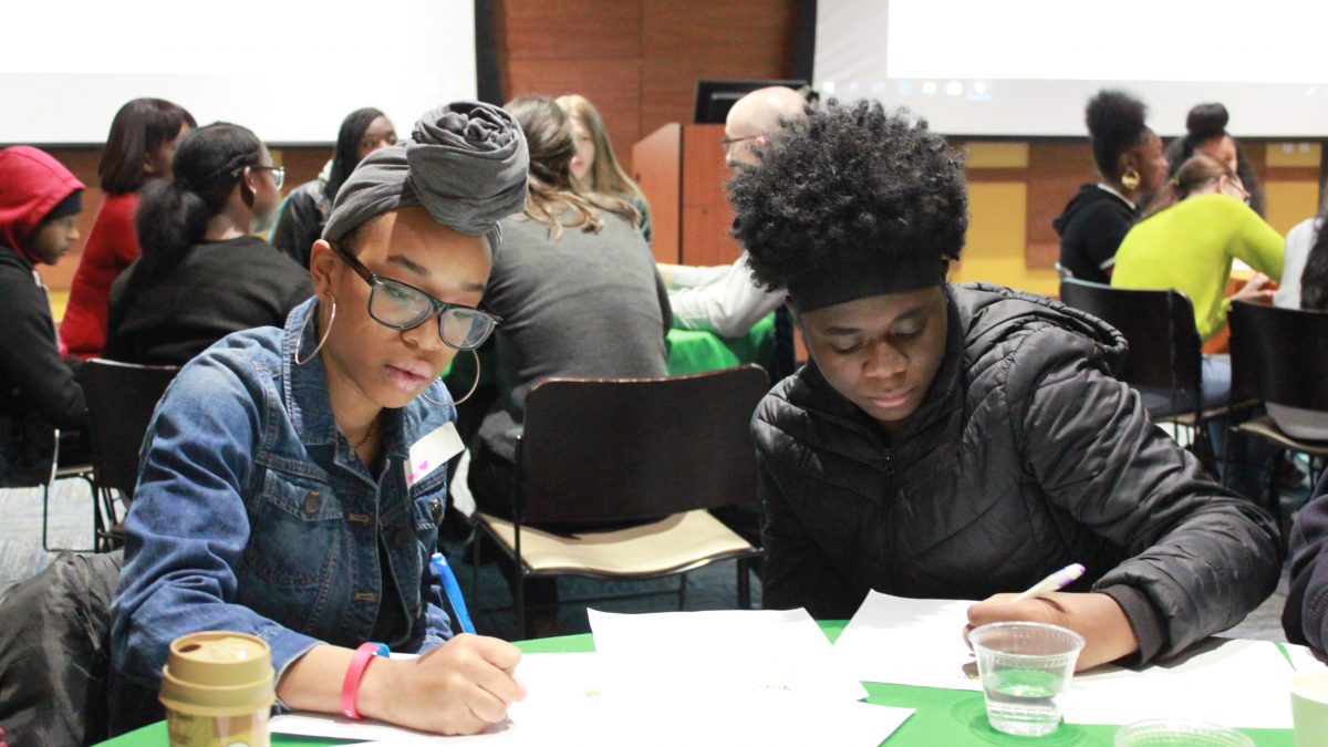 Two youth writing at table