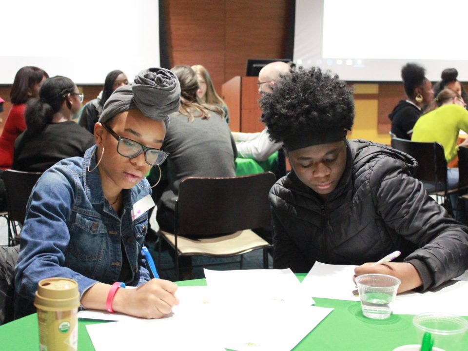 Two youth writing at table