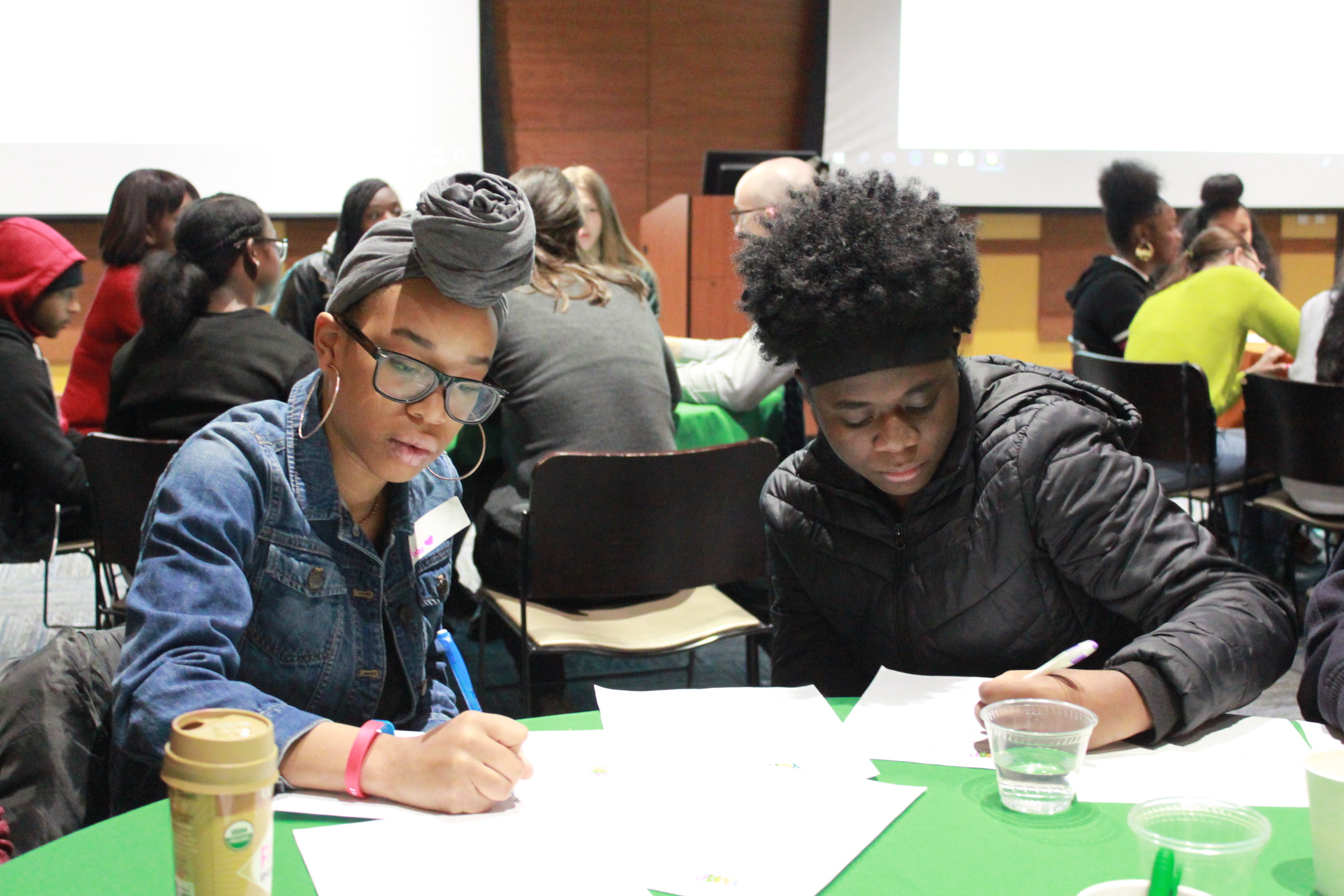 Two youth writing at table